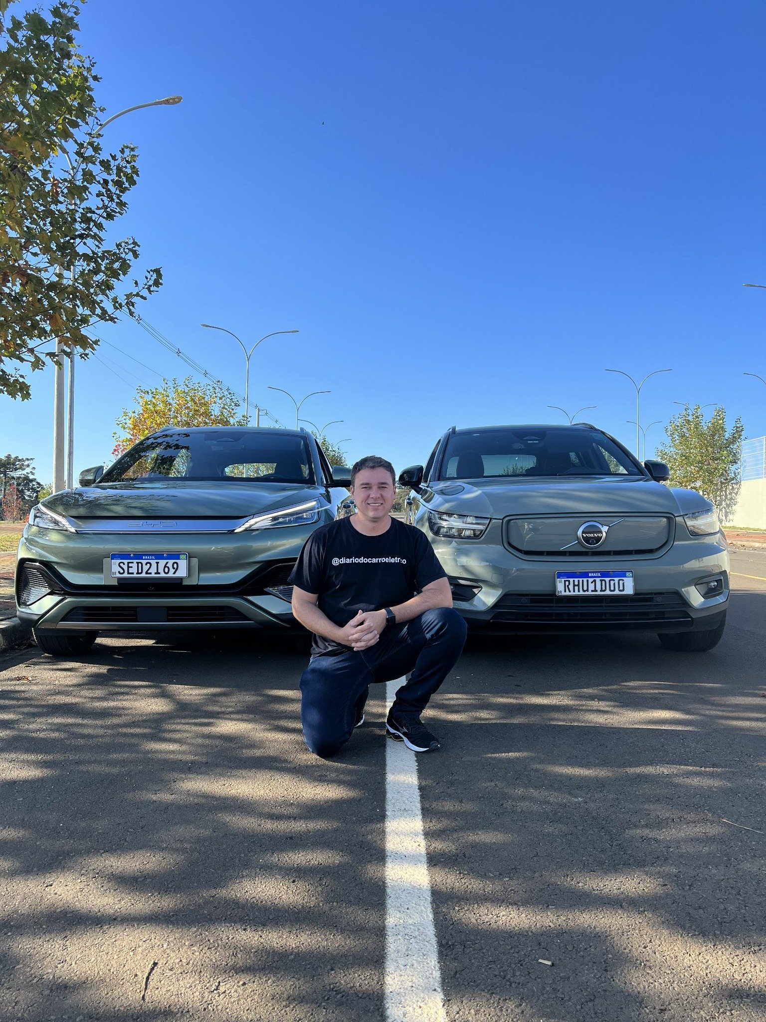 Marcos Paulo entre um BYD Yuan Plus e um Volvo XC40 Recharge